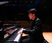 Danny Su at the piano on stage in Kulas Hall 